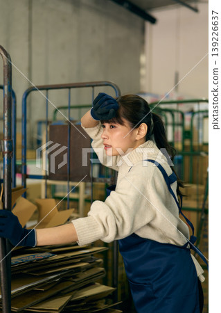 一位女士正在後屋整理紙箱。 139226637