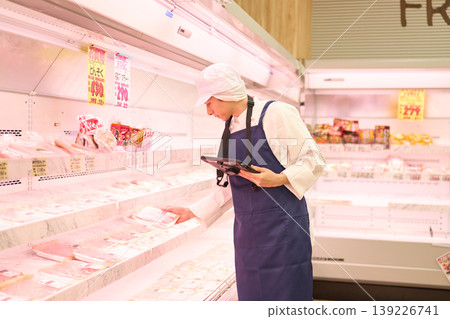 A clerk managing inventory at a supermarket A clerk managing inventory at a supermarket 139226741
