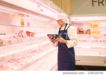 A clerk managing inventory at a supermarket A clerk managing inventory at a supermarket 139226742