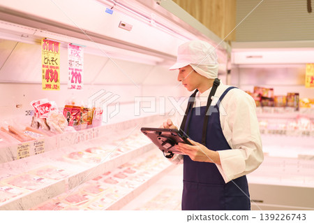 A clerk managing inventory at a supermarket A clerk managing inventory at a supermarket 139226743