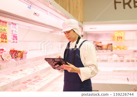 A clerk managing inventory at a supermarket A clerk managing inventory at a supermarket 139226744