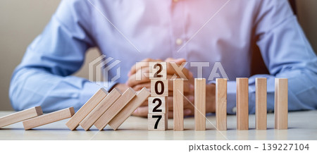 Businessman with 2027 wooden Blocks. Business, Risk Management, Insurance, Resolution, strategy, solution, goal, New Year New You and happy holiday concepts Businessman with 2027 wooden Blocks. Business, Risk Management, Insurance, Resolution, strategy, solution, goal, New Year New You and happy holiday concepts 139227104