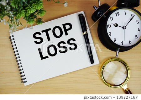 Stop Loss text written on notepad with alarm clock and magnifying glass flat lay on wooden background Stop Loss text written on notepad with alarm clock and magnifying glass flat lay on wooden background 139227167