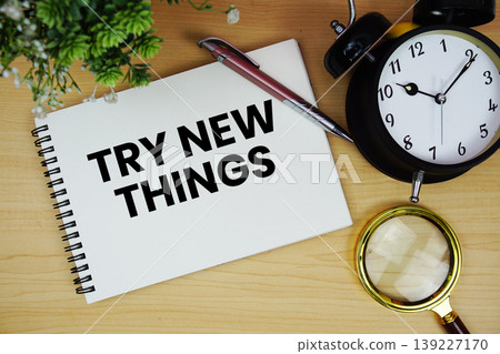 Try New Things text written on notepad with alarm clock and magnifying glass flat lay on wooden background Try New Things text written on notepad with alarm clock and magnifying glass flat lay on wooden background 139227170