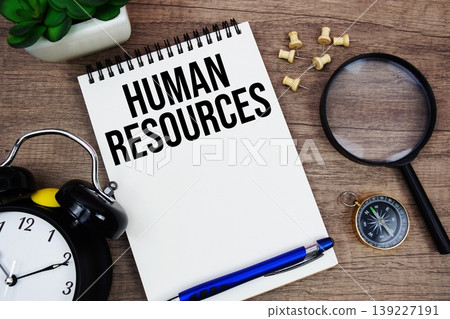 Human Resources text written on notepad with alarm clock, compass and magnifying glass flat lay on wooden background Human Resources text written on notepad with alarm clock, compass and magnifying glass flat lay on wooden background 139227191