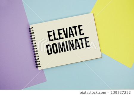 Elevate Dominate text written on notepad flat lay on multicolor pastel background 139227232