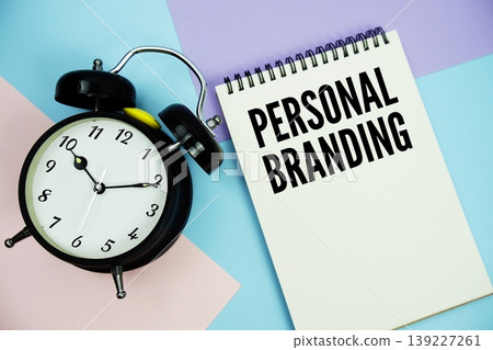 Personal Branding text written on notepad with alarm clock flat lay on multicolor pastel background 139227261