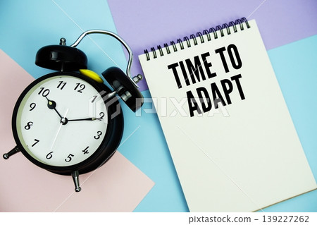 Time To Adapt text written on notepad with alarm clock flat lay on multicolor pastel background 139227262