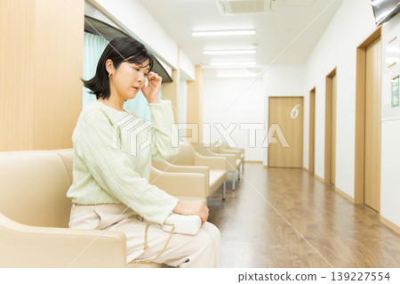A woman's profile while waiting for her doctor's appointment - a scene from a hospital waiting room. A woman's profile while waiting for her doctor's appointment - a scene from a hospital waiting room. 139227554