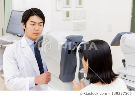 一位醫生和一位正在眼科診所接受視力檢查的病人。 一位醫生和一位正在眼科診所接受視力檢查的病人。 139227565