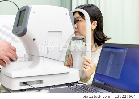 A woman undergoing a vision test at an ophthalmologist's office | Medical scene of presbyopia and cataract examination. A woman undergoing a vision test at an ophthalmologist's office | Medical scene of presbyopia and cataract examination. 139227604