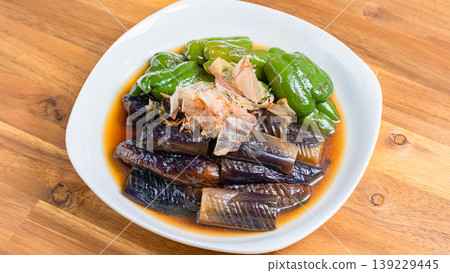 烤茄子和甜椒，用日式高湯醃製。一道用日式高湯醃製的夏季蔬菜配菜。木紋背景。 139229445
