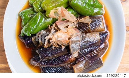 Grilled eggplant and bell peppers marinated in Japanese-style broth. A side dish of summer vegetables marinated in Japanese-style broth. Wood grain background. Grilled eggplant and bell peppers marinated in Japanese-style broth. A side dish of summer vegetables marinated in Japanese-style broth. Wood grain background. 139229447