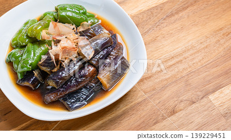 Grilled eggplant and bell peppers marinated in Japanese-style broth. A side dish of summer vegetables marinated in Japanese-style broth. Wood grain background. Grilled eggplant and bell peppers marinated in Japanese-style broth. A side dish of summer vegetables marinated in Japanese-style broth. Wood grain background. 139229451