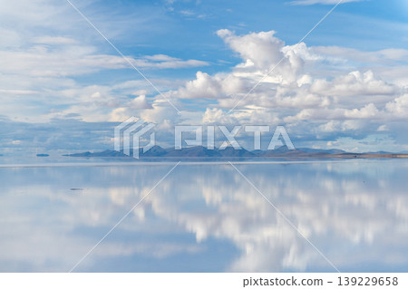 Serene reflection of cloudy sky on Salar de Uyuni water in Bolivia Serene reflection of cloudy sky on Salar de Uyuni water in Bolivia 139229658