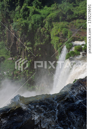 Breathtaking waterfall at iguazu falls cascade down lush green cliff Breathtaking waterfall at iguazu falls cascade down lush green cliff 139229691
