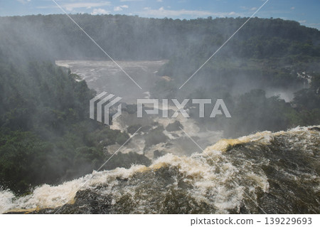 Powerful dramatic iguazu falls waterfall creating heavy mist over an awe inspiring lush gorge Powerful dramatic iguazu falls waterfall creating heavy mist over an awe inspiring lush gorge 139229693
