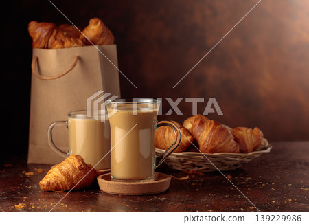 Coffee latte and croissants on a brown table. 139229986