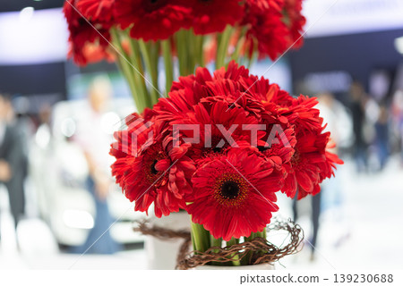 Close up of red gerbera flowers arranged in vase with soft blurred background showing vibrant petals fresh floral decoration and elegant event display 139230688