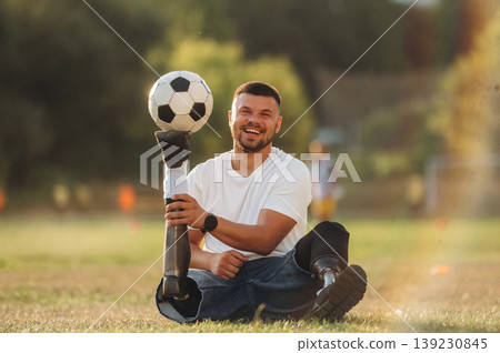 Soccer ball is on the shoe, having fun. Strong amputee man with prosthesis is on the field Soccer ball is on the shoe, having fun. Strong amputee man with prosthesis is on the field 139230845