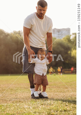 Bright sunlight, illuminated by it. The amputee father is with his son on the field Bright sunlight, illuminated by it. The amputee father is with his son on the field 139231149