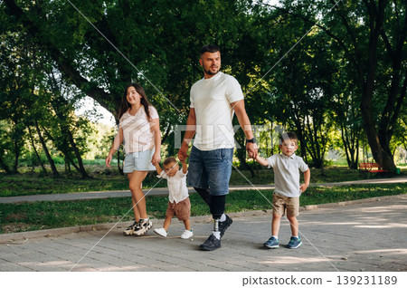 In the public park. Family of father that is amputee with prosthesis, mother and two kids In the public park. Family of father that is amputee with prosthesis, mother and two kids 139231189
