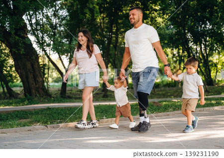 In the public park. Family of father that is amputee with prosthesis, mother and two kids 139231190