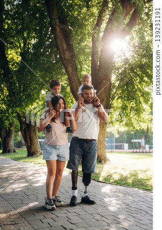 Family of father that is amputee with prosthesis, mother and two kids Family of father that is amputee with prosthesis, mother and two kids 139231191