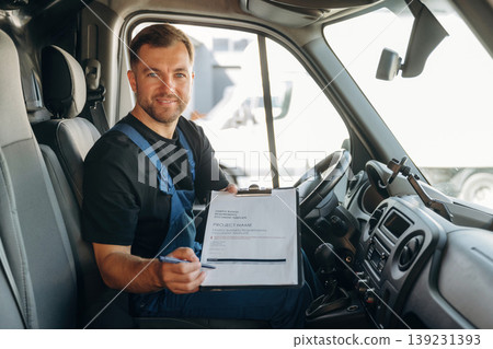 Just formal stuff, the notepad with document, invoice. Inside of the bus with delivery service man in uniform Just formal stuff, the notepad with document, invoice. Inside of the bus with delivery service man in uniform 139231393