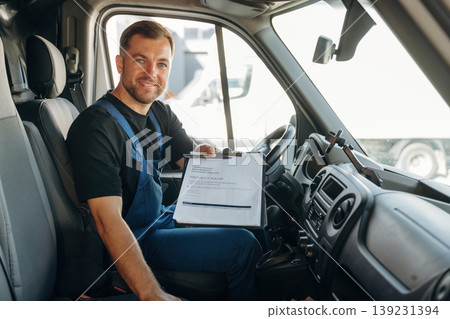 Just formal stuff, the notepad with document, invoice. Inside of the bus with delivery service man in uniform Just formal stuff, the notepad with document, invoice. Inside of the bus with delivery service man in uniform 139231394