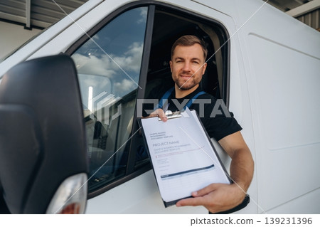 Document to fill out. Courier of delivery service company is sitting in the van Document to fill out. Courier of delivery service company is sitting in the van 139231396