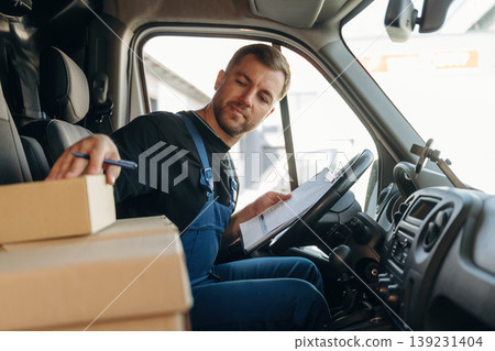 Checking the package. Inside of the bus with delivery service man in uniform Checking the package. Inside of the bus with delivery service man in uniform 139231404