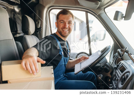 Checking the package. Inside of the bus with delivery service man in uniform Checking the package. Inside of the bus with delivery service man in uniform 139231406