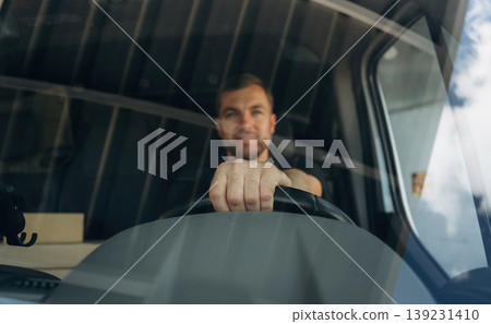 Front view of delivery man that is driving a van Front view of delivery man that is driving a van 139231410