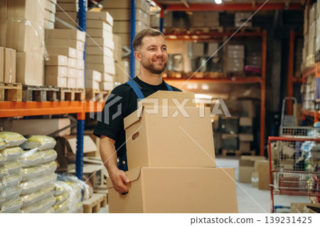 Many of the boxes. Man in uniform is working in the storage with packages for shipment 139231425