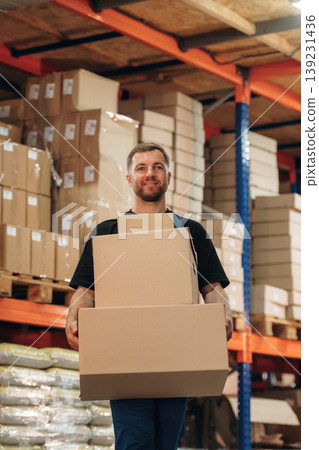 Man in uniform is working in the storage with packages for shipment Man in uniform is working in the storage with packages for shipment 139231436