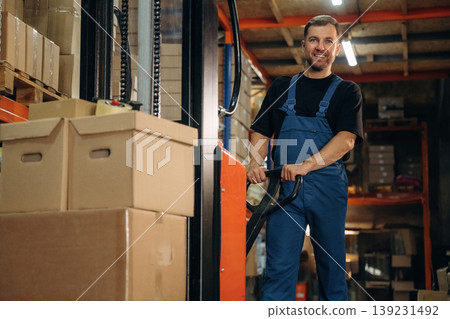 Man in uniform is working in the storage with packages for shipment Man in uniform is working in the storage with packages for shipment 139231492