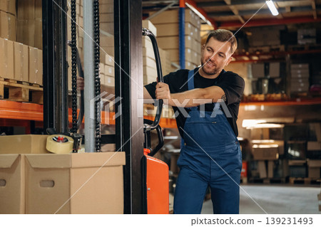 Man in uniform is working in the storage with packages for shipment Man in uniform is working in the storage with packages for shipment 139231493