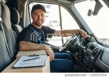 Document lying down on the box. Inside of the bus with delivery service man in uniform 139231558