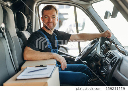 Document lying down on the box. Inside of the bus with delivery service man in uniform Document lying down on the box. Inside of the bus with delivery service man in uniform 139231559