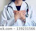 A female doctor with both hands on her chest. 139231566