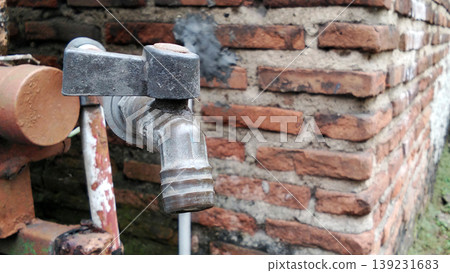 Old Water Tap on Brick Wall with Textured Details Old Water Tap on Brick Wall with Textured Details 139231683