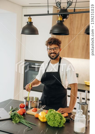 Handsome man is preparing food on the kitchen Handsome man is preparing food on the kitchen 139231819