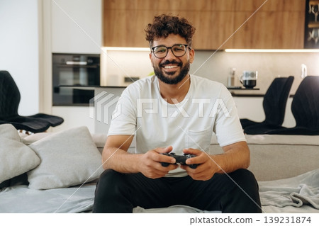 Gamer is with controller in hands. Man is in the modern domestic room at home Gamer is with controller in hands. Man is in the modern domestic room at home 139231874