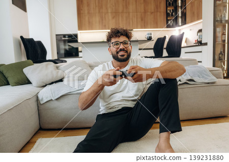 Enjoying playing video games, with controller. Man is in the modern domestic room at home 139231880