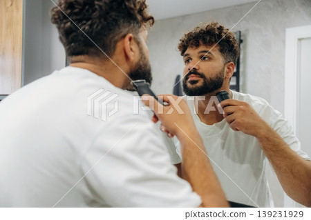 Process of brushing the teeth. Guy is in the bathroom, taking care of his appearance Process of brushing the teeth. Guy is in the bathroom, taking care of his appearance 139231929