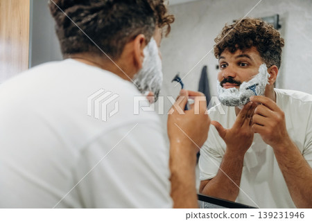 Shaves the beard. Guy is in the bathroom, taking care of his appearance 139231946