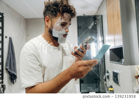 Face mask, beauty conception. Guy is in the bathroom, taking care of his appearance Face mask, beauty conception. Guy is in the bathroom, taking care of his appearance 139231958