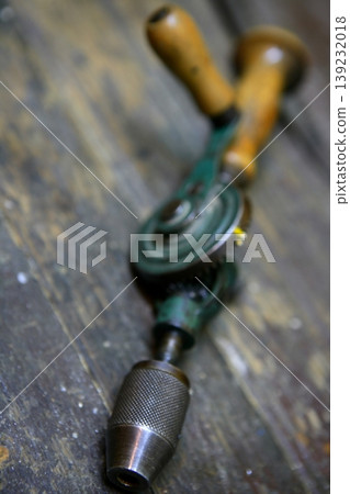 Drill tool old style with hand human energy in green over  wood table 139232018