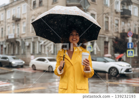 With black umbrella. Happy young woman in the city during the rain With black umbrella. Happy young woman in the city during the rain 139232193